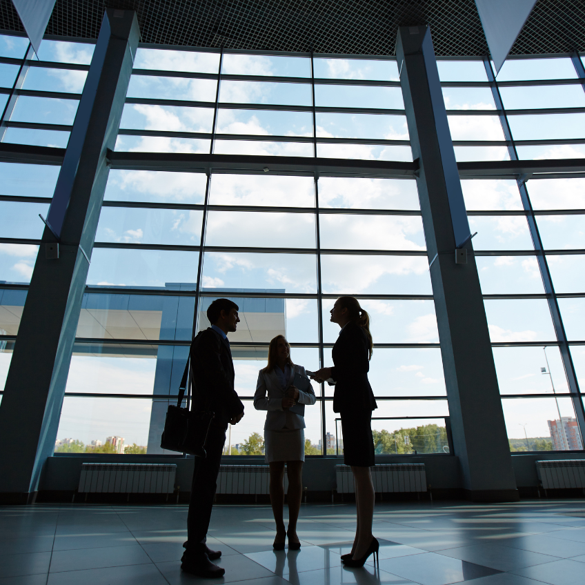Business colleagues chatting together in well lit buiding